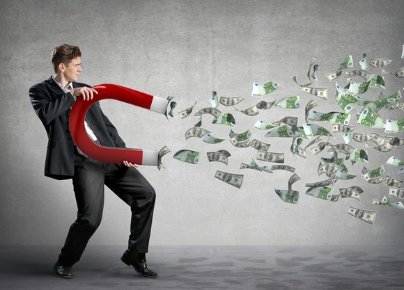 dividend-income-business-man-with-giant-magnent-attracting-money_large_large