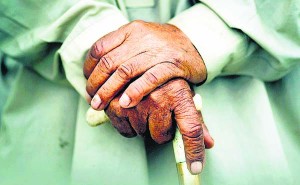 100-year-old local resident Babou Zay holds his walking stick as he talks to a journalist about his damaged house near Mingora in Pakistan's Swat Valley