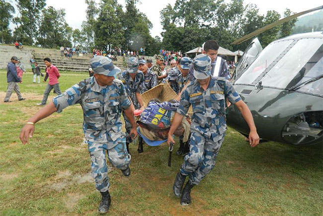 ताप्लेजुङको पहिरोमा परी घाइते भएकाहरुलाई धरानस्थित बि पि मेमोरियल अस्पातलतर्फ लैजाँदै सुरक्षाकर्मीहरु । तस्वीरः एपीएफ