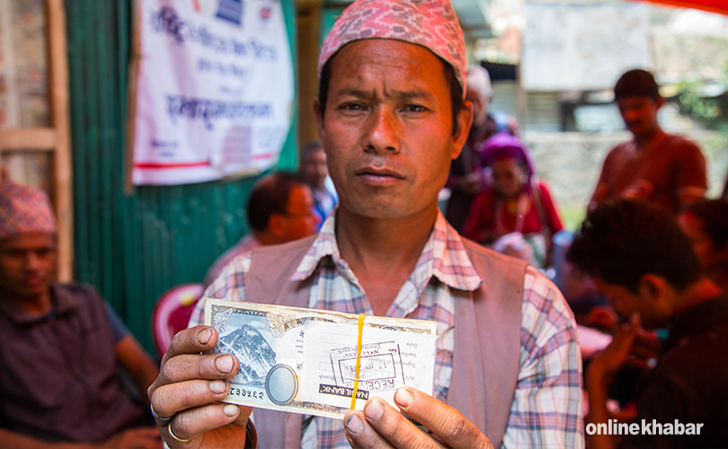 दोलखामा वितरण भएको अनुदान रकम देखाउँदै सर्वसाधारण 