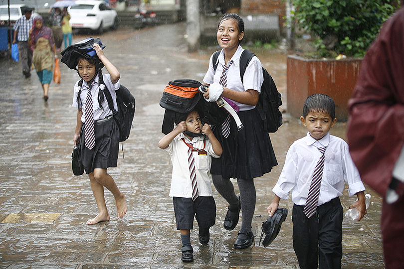 Children coming back from the school on a monsoon rain in Lalitpur.