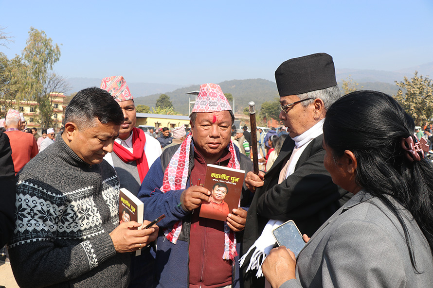 राष्ट्रियसभा निर्वाचनको मतदानस्थल बाहिर पुस्तक बेच्दै महावीर पुन