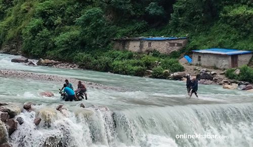 बाढीले पुल बगाएपछि ताक्सुगाडमा जोखिम मोलेर वारपार गर्छन् सर्वसाधारण (तस्वीरहरू)