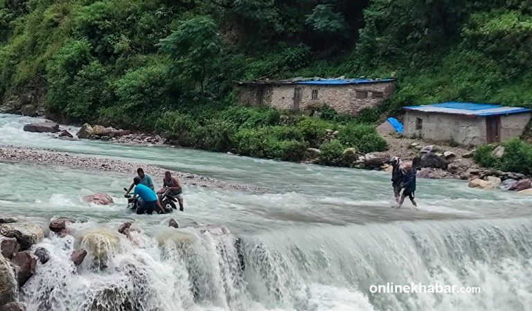 बाढीले पुल बगाएपछि ताक्सुगाडमा जोखिम मोलेर वारपार गर्छन् सर्वसाधारण (तस्वीरहरू)